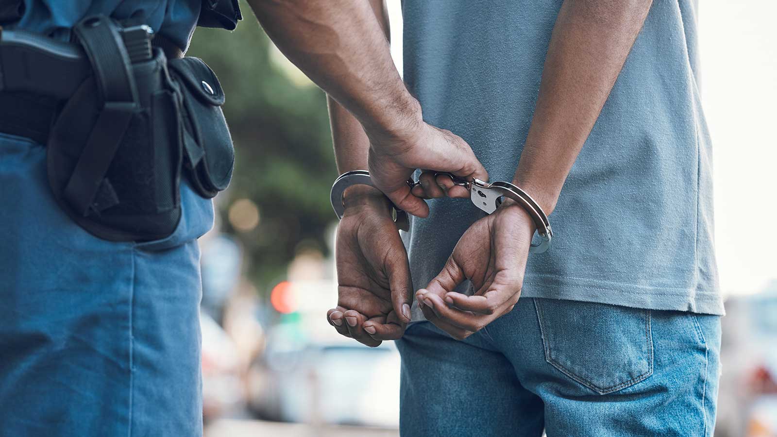 Officer handcuffing a person during a drug arrest